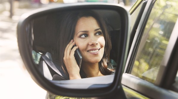 Renault Minute - Une femme brune téléphone depuis son véhicule à l'arrêt